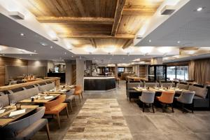 a restaurant with tables and chairs and a bar at Residence Alexane in Samoëns