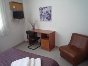 Habitación pequeña con escritorio y silla. en Hostal Residencia Ponte Vella, en Lugo