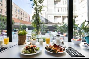 uma mesa com pratos de comida em cima em Andante Hotel em Barcelona