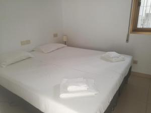 ネルハにあるADOSADO EN NERJA URB FLAMINGOの窓付きの客室で、白いベッド2台が備わります。