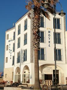 uma palmeira em frente a um edifício em Blue Moon Hotel em Pantelleria