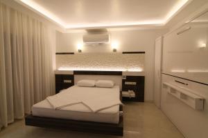 Kas Maki Hotel في كاس: غرفة نوم عليها سرير ومخدات بيضاء
