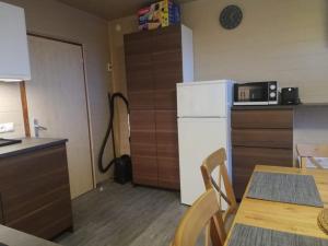 kuchnia ze stołem i białą lodówką w obiekcie Apart Family Schweng w mieście Tux