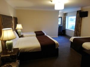 a hotel room with two beds and a window at Castle Lodge in Killarney