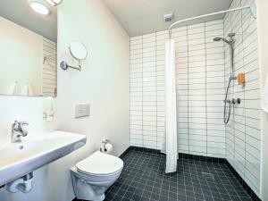 a bathroom with a toilet and a sink and a shower at Rønne Hotel in Rønne