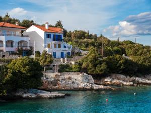 une maison sur une colline à côté de l'eau dans l'établissement Fey's House waterfront - Φισκάρδο, à Fiskardho