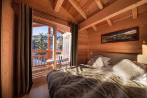 Un dormitorio con una cama y una ventana grande. en Hotel & Restaurant Les Escondus, en Vars