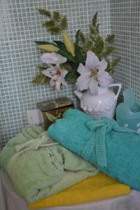 een handdoek en een vaas met bloemen op een tafel bij B&B Al Mare Di Greis in Lido Adriano