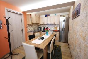 Una cocina con una mesa de madera y un refrigerador. en Villa Makrades 2, en Paleokastritsa