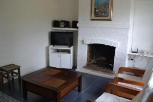 a living room with a fireplace and a tv at Kactus- Balneario Buenos Aires in Balneario Buenos Aires