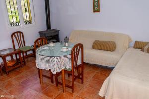 Una sala de estar con una mesa y sillas y un sofá. en Apartamento El Serrano, en Benaoján 14 fotos más