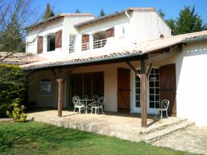 ein Haus mit Stühlen und einem Tisch im Hof in der Unterkunft Mas du Trezon in Cholet