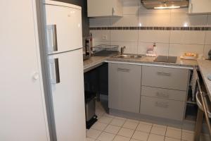 a kitchen with white cabinets and a white refrigerator at STUDIO CENTRE VILLE COMPIÈGNE in Compiègne