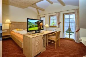 1 dormitorio con 1 cama y escritorio con TV en Gasthaus Sonne, en Münstertal