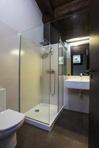 a bathroom with a shower and a toilet and a sink at Cal Sadurní in Bruguera