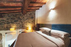 a bedroom with a bed and a stone wall at Torre di Baratti Bio Resort in Populonia