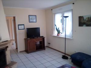 a living room with a television and a window at Les gîtes du lindenberg in Dambach
