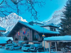 un hotel in montagna con auto parcheggiate di fronte di Hotel Eigerblick a Grindelwald