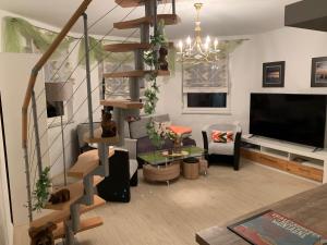 ein Wohnzimmer mit einer Wendeltreppe und einem TV in der Unterkunft Villa Fallingstar in Bad Saarow