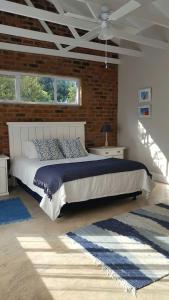 um quarto com uma cama grande e uma parede de tijolos em Nova Skye em Joanesburgo