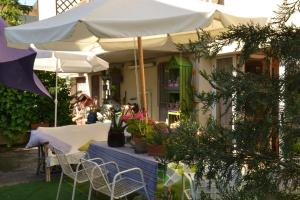 a patio with tables and chairs and an umbrella at B&B Al Mare Di Greis in Lido Adriano