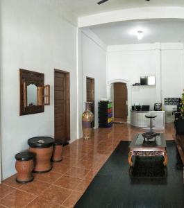 a living room with a couch and a table at Kana Hasya Homestay "Rumoh Jamee" in Meulaboh