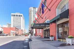 a red building with a pizza shop sign on a street at Plaza Suites Downtown New Orleans in New Orleans