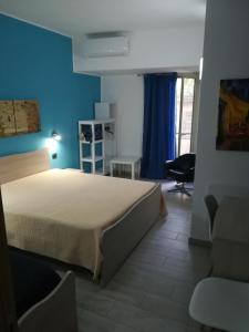 1 dormitorio con cama y pared azul en Piazza Castello, en Santo Stefano Quisquina