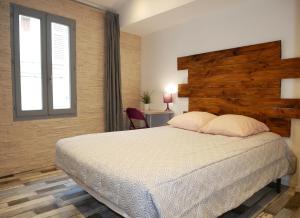 a bedroom with a large bed and a window at L'Oriflamme in Avignon
