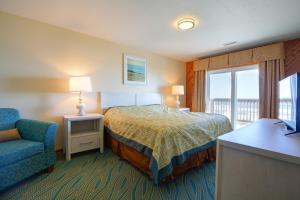 Ocean Pines Resort by Capital Vacations في دوك: غرفه فندقيه بسرير وكرسي ونافذه