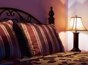 a bed with two pillows and a lamp on it at Aiolides Traditional Homes in Asprangeloi