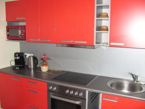 a kitchen with red cabinets and a sink at Gratarre 2 in Kuressaare