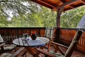 a wooden deck with a table and chairs on a porch at Za Siódmą Górą in Zachełmie