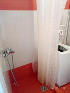 a bathroom with a shower with a red floor at Cozy Apartment With Side View of Acropolis in Athens