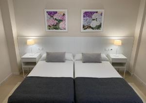 łóżko w pokoju z dwoma stołami i dwoma lampami w obiekcie APARTAMENTO MARIPOSA II w mieście Conil de la Frontera