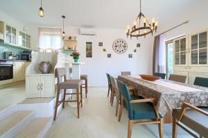 uma cozinha e sala de jantar com mesa e cadeiras em Villa Nathalie - Linardici, Krk em Linardići