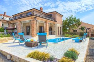 a patio with chairs and a swimming pool at Villa Nathalie - Linardici, Krk in Linardići