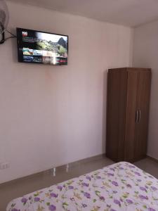 a bedroom with a bed and a tv on the wall at Hospedaje Villa Del Sol in Ica +15 photos