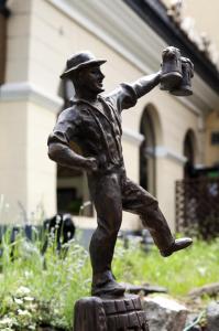 a bronze statue of a man holding a bucket at Wien Hotel in Lviv