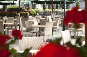 a row of chairs and tables in a patio with flowers at Wien Hotel in Lviv