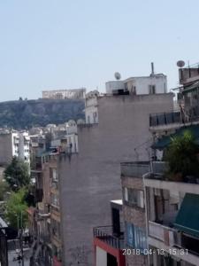 a view of a city with tall buildings at Cozy Apartment With Side View of Acropolis in Athens