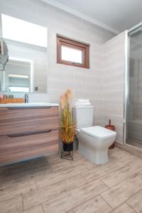 a bathroom with a toilet and a tub and a sink at Hotel Boutique Puramar in Curanipe