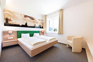 ペルトシャッハ・アム・ヴェルターゼーにあるStrandhotel Kärntnerhofのベッドと窓が備わるホテルルーム