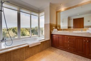 a bathroom with a tub and a large window at Arcos Gardens Sol Rent Golf in Arcos de la Frontera