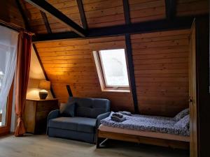 Nad Strumyczkiem - pokoje gościnne - Apartamenty z przymróżeniem oka في شتوروك: غرفة معيشة مع أريكة ونافذة
