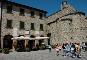 un gruppo di persone che camminano davanti a un edificio di San Leo Albergo Diffuso a San Leo
