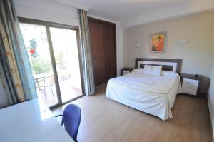 1 dormitorio con cama y ventana grande en Hotel Goya, en Almuñécar