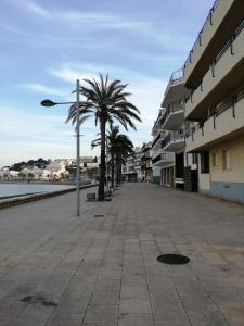 una calle con palmeras y un semáforo en Apartament Passeig Maritim en Llança