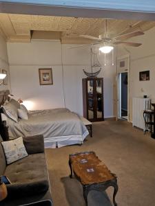 a bedroom with a bed and a couch and a table at Canalside Restaurant, Inn & Kitchen Store in Port Colborne