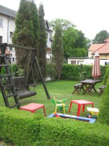 a playground with chairs and a swing and a table at Pokoje DAJAN in Łeba